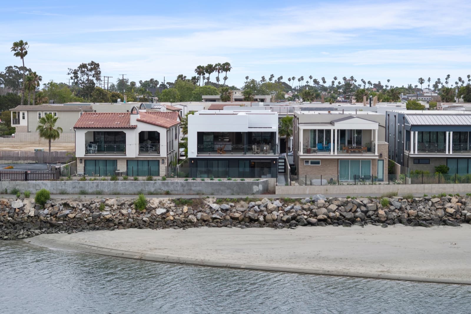 Waterfront homes at 205 Ocean Place viewed across the beach and rock jetty