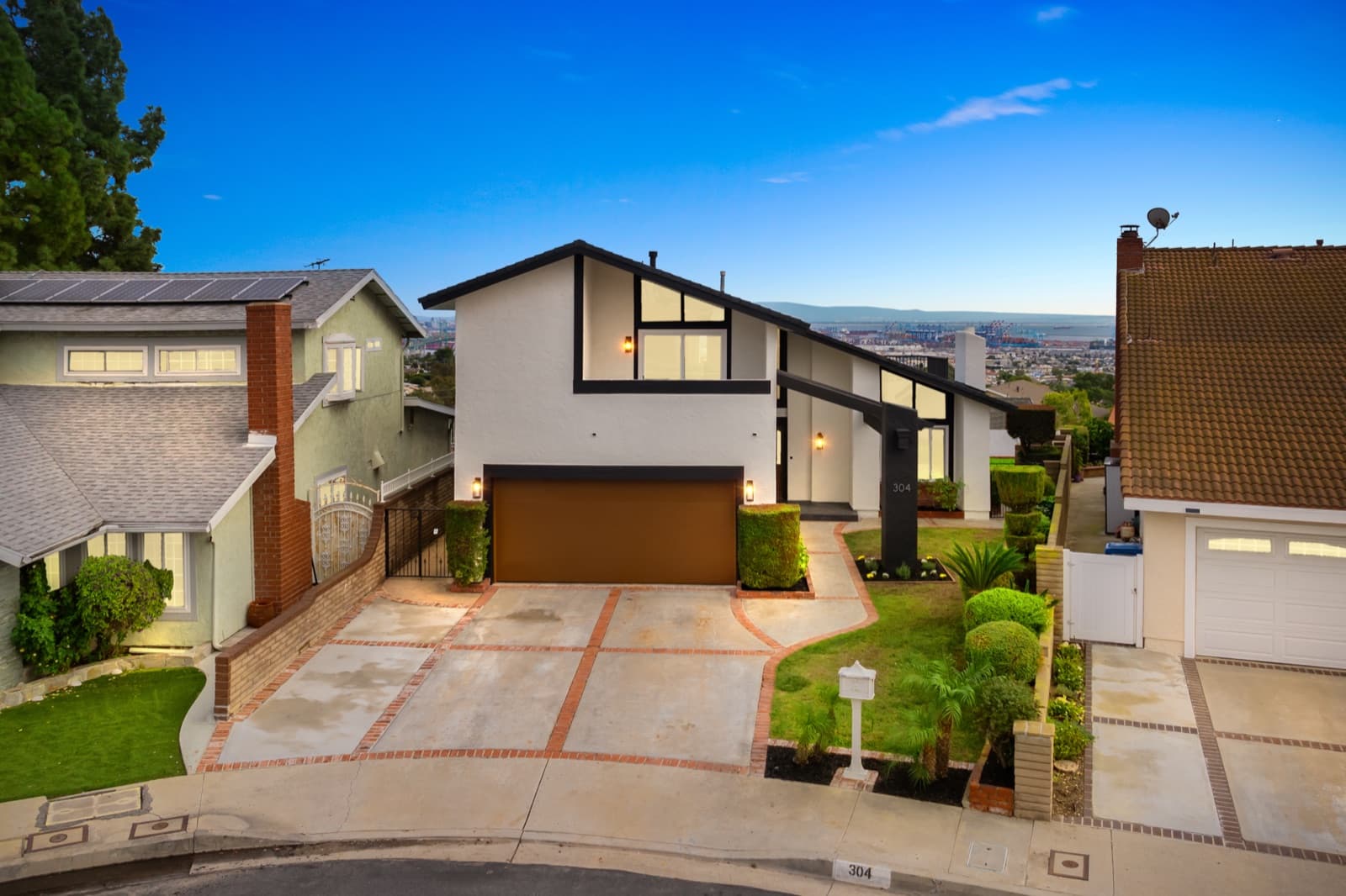 Twilight exterior of a modern two-story home at 304 John Way with harbor views in the background