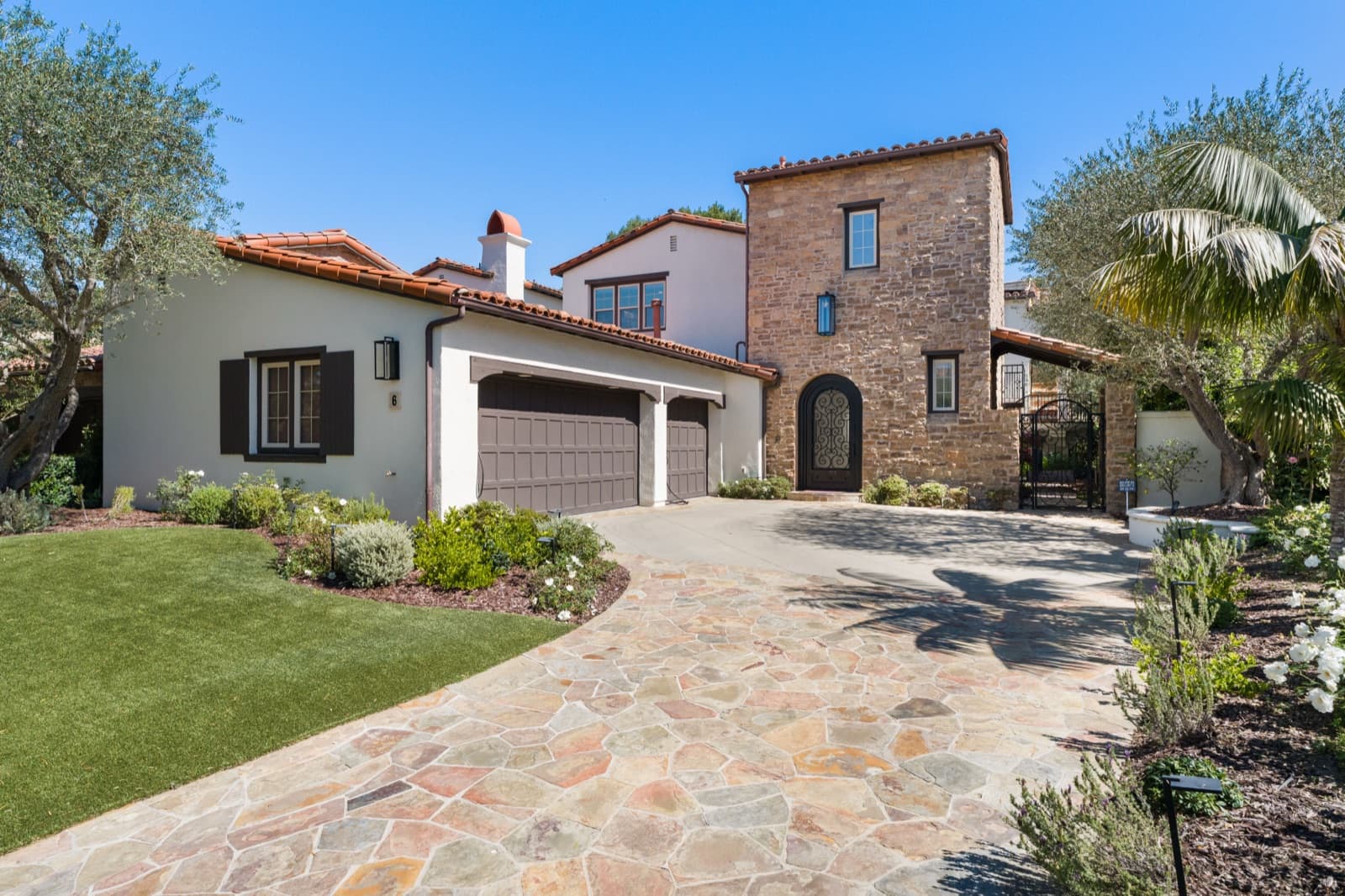 Tuscan-style two-story estate at 6 Castellina Drive with a stone tower entry